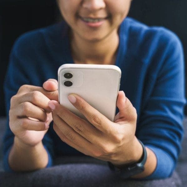 girl in blue shirt looks at cell phone