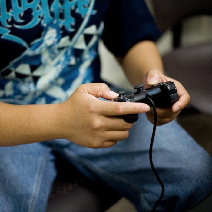 Young person holding Playstation controller