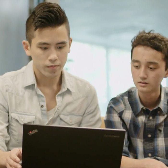 Teens looking at laptop